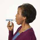 Woman using peak flow meter.